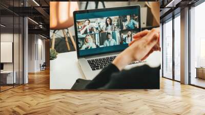 Woman has video conference with her remote team using laptop and camera Wall mural