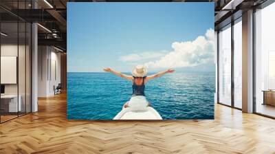 Young and happy woman traveling on the boat in the ocean Wall mural