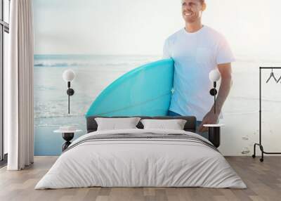 Young guy surfer walking with surfboard near the ocean Wall mural