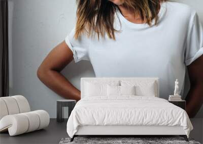 Young woman in white blank t-shirt, wearing glasses, grunge wall, studio portrait. Wide screen, panoramic Wall mural