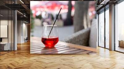 Glass of red juice on a wooden table on a summer terrace Wall mural