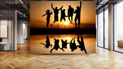 silhouette of friends jumping on beach in sunset Wall mural