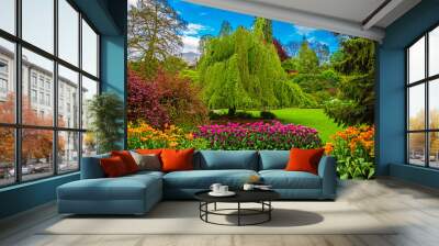 Queen Elizabeth Park Vancouver. Blossoming flower beds in  city park. Beautiful natural landscape gardening concept. Flowers and trees at the background of blue cloudy sky Wall mural