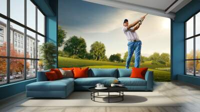 Male golf player on professional golf course. Golfer with golf club taking a shot Wall mural