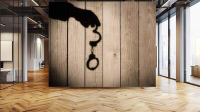 Male Hand with Handcuffs on Natural Wood Background, XXXL. Wall mural