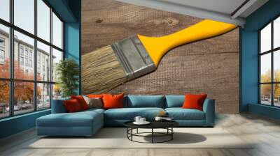 Paint brush width 2 inch with yellow handle on a wooden background close-up Wall mural