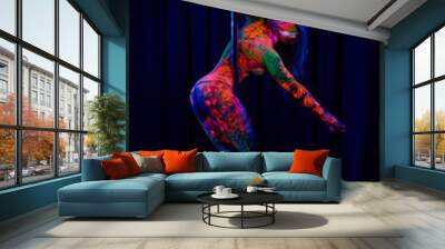 Female pole dancer in bright neon colours under ultraviolet (UV) light on background Wall mural