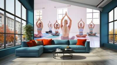 People, yoga class and instructor in stretching, fitness or wellness for mindful, wellbeing or health. Women, pose and studio for balance, gym and together in activity, training or spiritual practice Wall mural