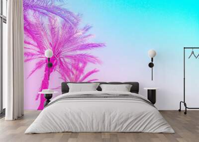 Silhouette of palm trees with a bright summer gradient on a bright blue background of the summer sky. Tropic, vacation and travel concept Wall mural