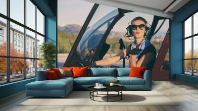 Attractive woman pilot sitting in the helicopter Wall mural