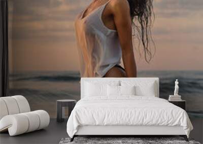 Sexy woman posing on beach near the sea at sunrise Wall mural