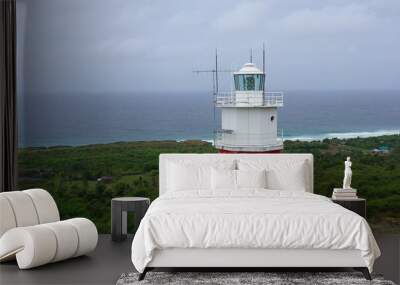 White tower lighthouse on a large island, top view. Rainforest hill and lighthouse tower. Bolinao Lighthouse, Luzon, Philippines. Summer and travel vacation concept. Wall mural