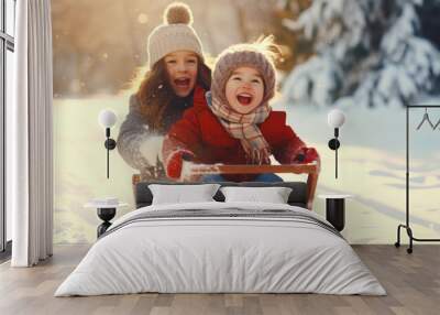 Two cute little girls having fun on a sled in the winter forest Wall mural