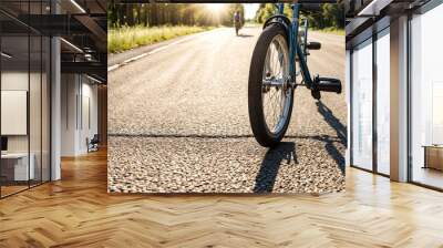 Close-up wheel of children's bikes riding on asphalt road summertime outdoors, sun shadow. Child going on small bicycle, summer day. Childhood leisure activity concept. Copy advertising text space Wall mural