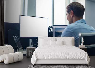 Rear view of young man businessman broker agent in shirt working using pc computer at desk in corporate office, from behind. Concept of business development growth and solutions. Copy ad text space Wall mural