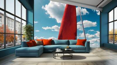 Sailboat with open scarlet sail in sea at blue sky with clouds horizon background. Luxury summer adventure on sailing yacht. Transportation, cruise, sailing, yachting concept. Copy text space Wall mural