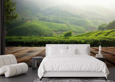 Wooden table top on green tea plantation with morning light, natural background Wall mural