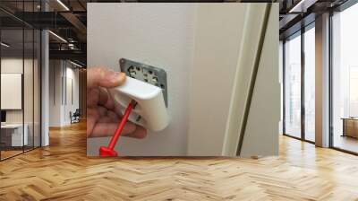 Сlose up view of electrician repairing wall light switch panel. Building construction elements concept.  Wall mural