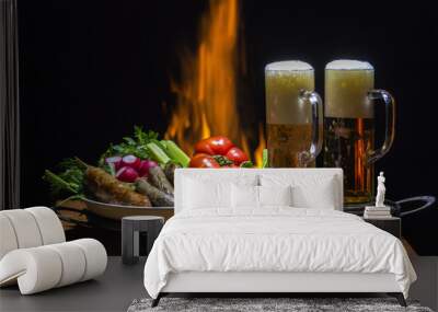 two beers and sausages with flame on background Wall mural