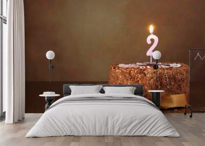 birthday chocolate cake with burning candle as a number two on brown background Wall mural