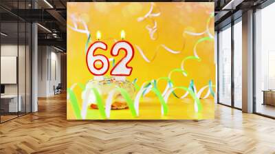 Sixty two years birthday. Cupcake with burning candles in the form of number 62. Bright yellow background with copy space Wall mural