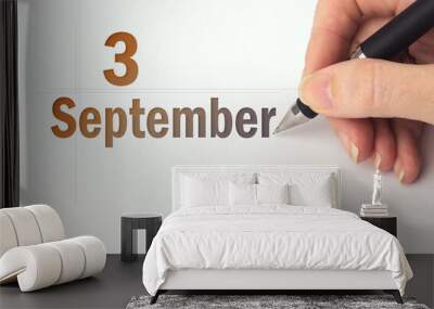 September 3rd. Day 3 of month, Calendar date. The hand holds a black pen and writes the calendar date. Autumn month, day of the year concept. Wall mural