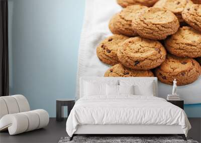 A bunch of oatmeal cookies with chocolate on a napkin on a blue background Wall mural