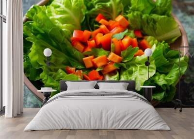 An assortment of bright green lettuce leaves are neatly arranged in a pale pink bowl accented by diced orange carrots and red pepper slices that add dynamic visual interest Wall mural