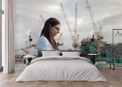 architect on the construction site makes supervision. Young female engineer with tablet computer in hand. Wall mural