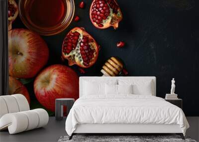 A colorful display of fresh pomegranates, apples, and honey on a table Wall mural