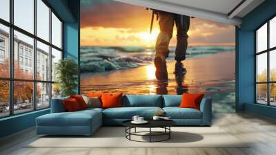 A person strolling along the shoreline as the sun sets behind them, creating a warm glow Wall mural