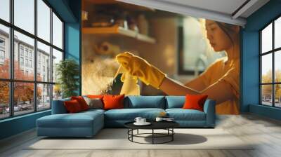 A woman wearing yellow gloves holds a bottle of cleaner and sprays it, Wall mural