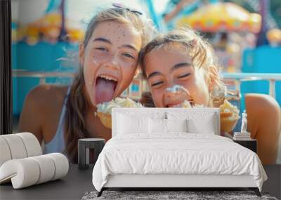 Two young women enjoying snacks at a vibrant carnival setting Wall mural