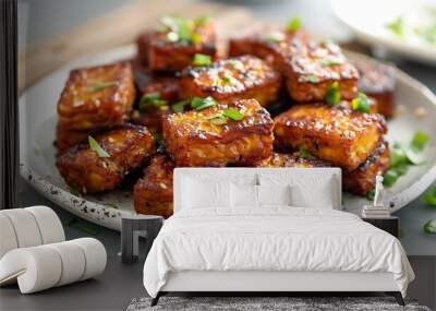 Crispy fried tempeh on a white plate with a gray plank background Wall mural