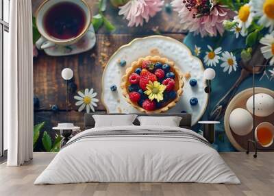 Flowers on the romantic breakfast table selective focus blured mini tartlet or pies crust with berries espresso coffee cup hard boiled egg water flowers directly above Wall mural