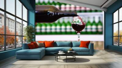 From the bottle the wine is poured into the glass. Wall mural