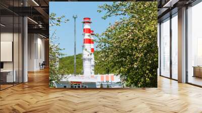 Gas turbine power plant on natural gas with chimneys of red-white color against the blue sky in the apple orchard Wall mural