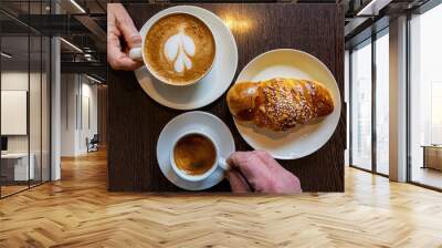 Malmo, Sweden Two coffees on a cafe table with a sweet bun and hands. Wall mural