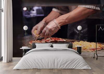 Man making pizza at the kitchen. Ingredients for Italian pizza. Gloved hands. Wall mural