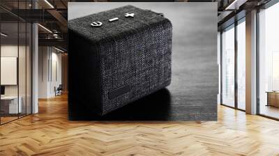 musical bluetooth column covered in denim on a dark wooden background. Wall mural