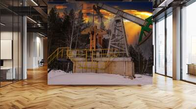 Oil pump jack winter working. At the orange sunset dawn of the sky with clouds. Oil rig energy industrial machine for petroleum in the sunset background for design. Nodding donkey Wall mural