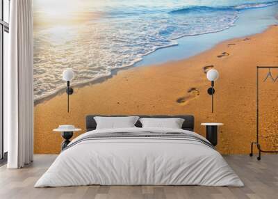 beach, wave and footprints at sunset time Wall mural