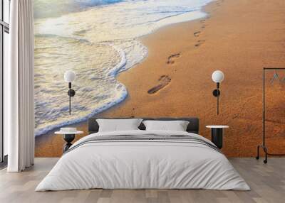 beach, wave and footprints at sunset time Wall mural