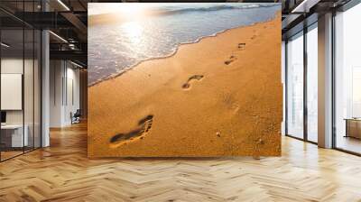 beach, wave and footprints at sunset time Wall mural