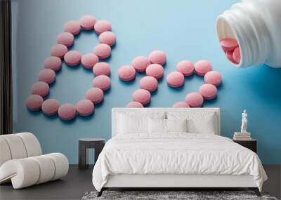 Pink round vitamins B12 shaped pills on a blue background spilled from a white can Wall mural