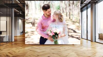 Happy wedding couple hugging and kissing. Beautiful young bride and groom, just married. Couple in love. Shallow focus and some noise. Wall mural