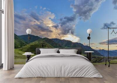 sunset luminous clouds above green mountains Wall mural