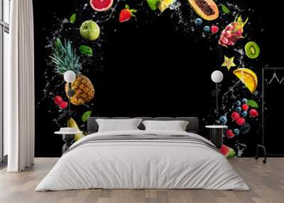 Assortment of fresh fruits and water splashes on black background Wall mural