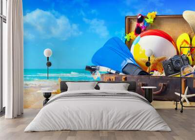 Beach accessories in suitcase on sand. Family holidays concept Wall mural