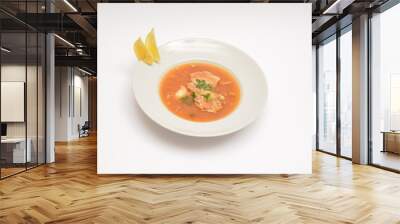 Tomato meat soup in a white plate on a white plate. Decorated with two lemon wedges. Can be used in the restaurant menu. Wall mural